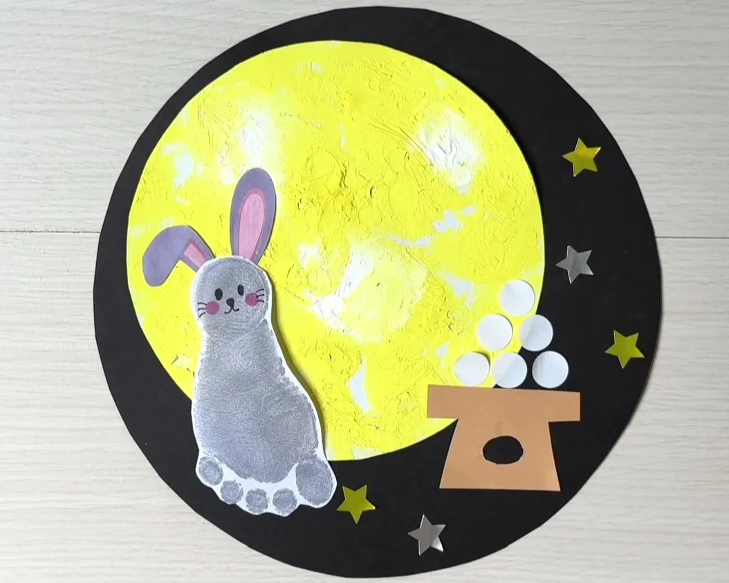 星のシールを黒い画用紙に貼っている画像