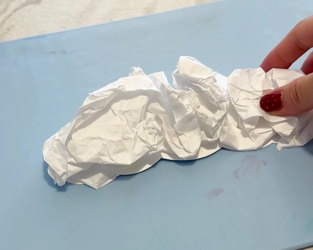 丸めた半紙を厚紙に貼り付けている様子