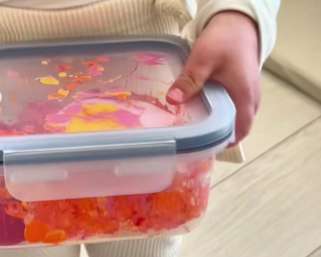 蓋を閉めた保存容器を振っている様子