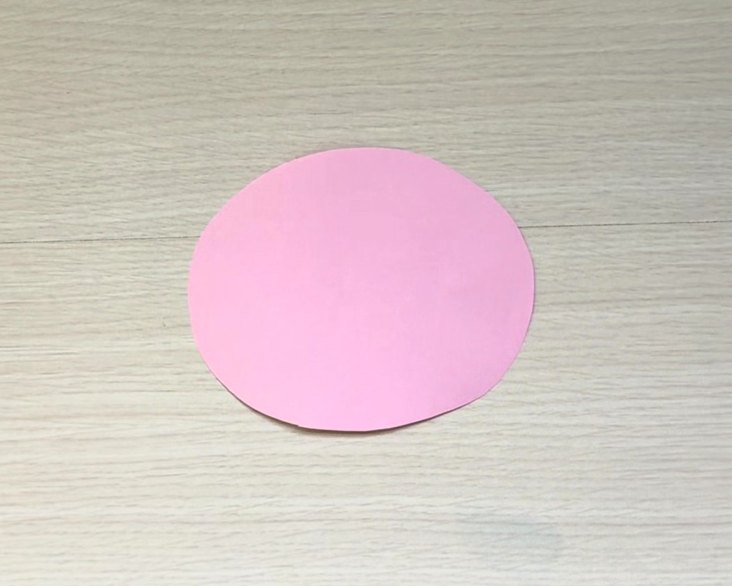ピンクの画用紙を楕円形に切った画像