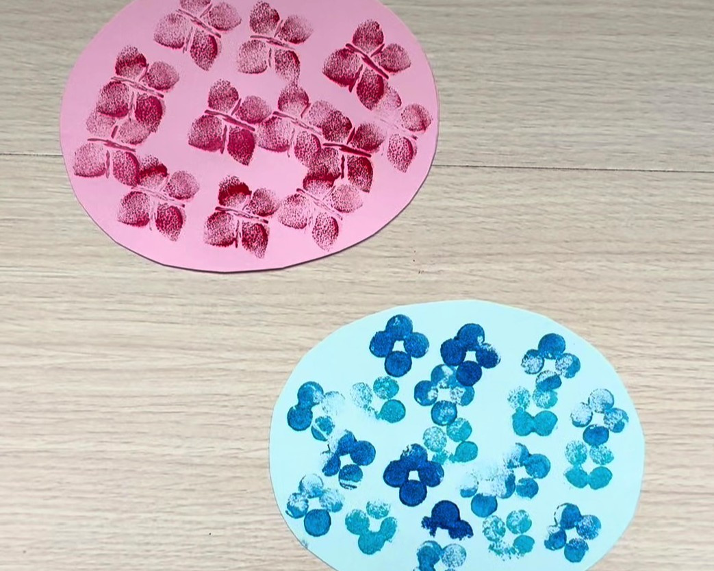 ピンクと水色の画用紙に先ほど作ったお花のスタンプを押した画像