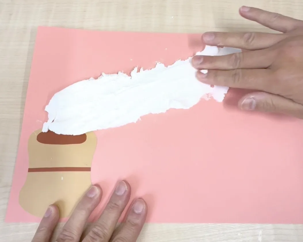 紙粘土を画用紙の右上に向かって伸ばすイメージ